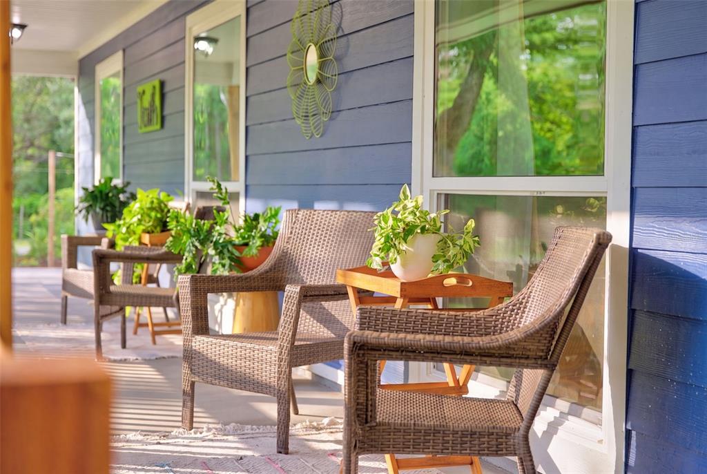 A covered porch with blue siding, a bright green door, and a wooden railing — 9990 SW COUNTY ROAD 769, ARCADIA, FL