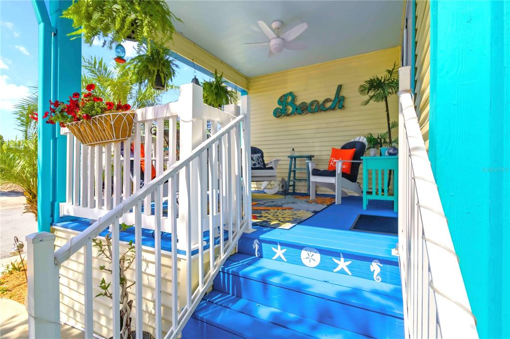 A blue and beige manufactured home features a front porch, palm trees, and a carport — 915 50TH AVENUE W, BRADENTON, FL