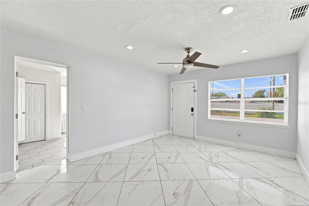 A room with white walls, a ceiling fan, and white marble-patterned tile flooring — 7805 WINSTON LANE, TAMPA, FL
