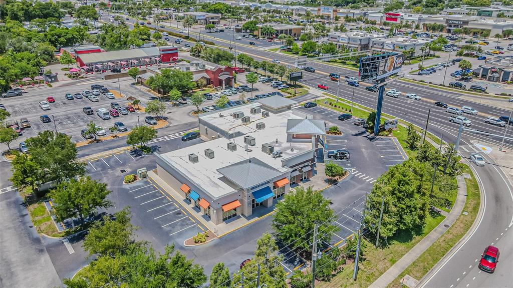 An aerial view shows a commercial building with a parking lot surrounded by roads — 5395 E BAY DRIVE, CLEARWATER, FL