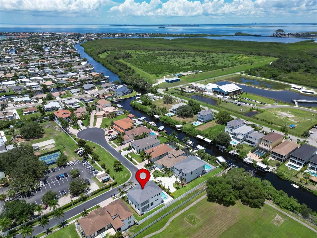 An aerial view shows a waterfront house with a pool and a red location pin — 517 TREVISO DRIVE, APOLLO BEACH, FL
