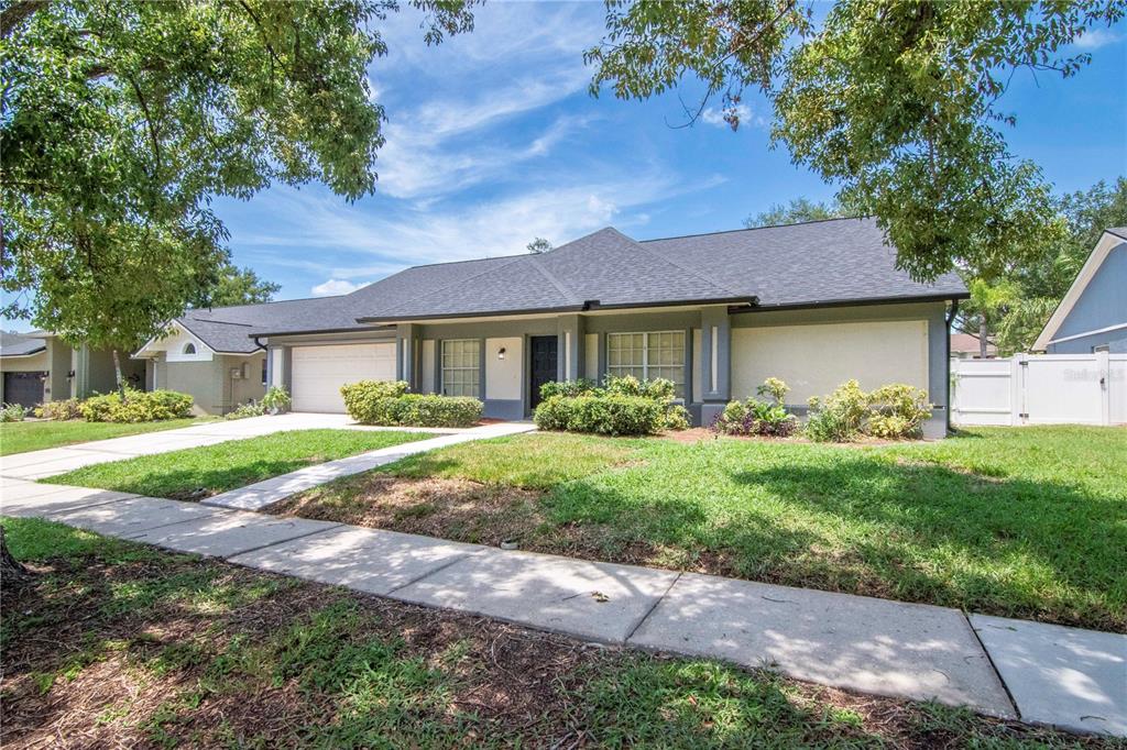 A single-story house with a gray exterior, a two-car garage, and a front lawn — 2608 BERRYVINE PLACE, VALRICO, FL