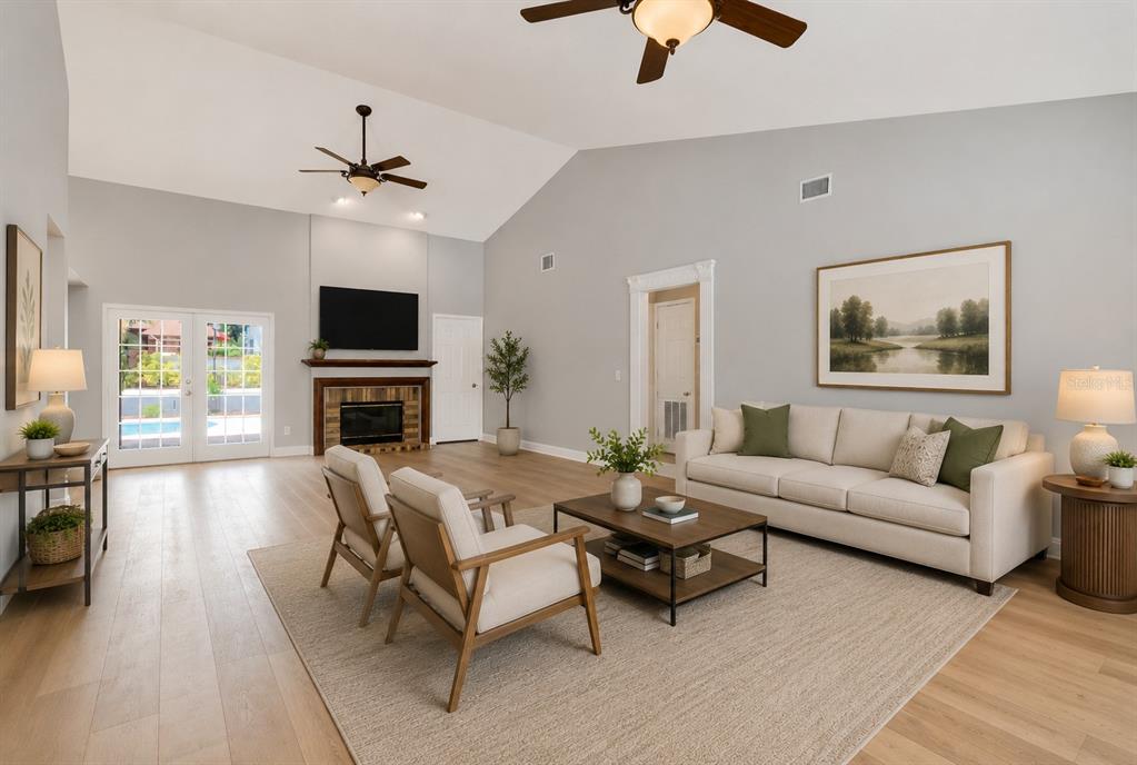 A living room features a fireplace, vaulted ceiling, light wood floors, and a beige sofa — 2608 BERRYVINE PLACE, VALRICO, FL