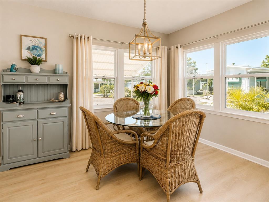 A dining area features a glass-topped wicker table, four wicker chairs, and a gray hutch — 6621 MARINA DRIVE, BRADENTON, FL