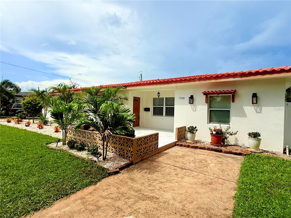 A single-story house with a red tile roof and a front lawn with palm trees — 1500 77TH STREET N, ST PETERSBURG, FL
