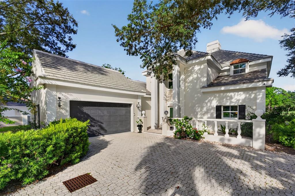 A two-story house with a gray tile roof, stucco exterior, and a paved driveway — 226 SAINT JAMES PARK, OSPREY, FL