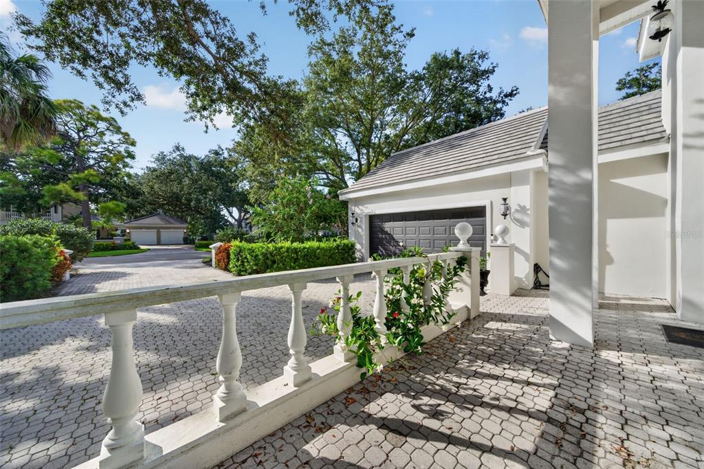 A white balustrade lines a paved driveway leading to a garage next to a house — 226 SAINT JAMES PARK, OSPREY, FL