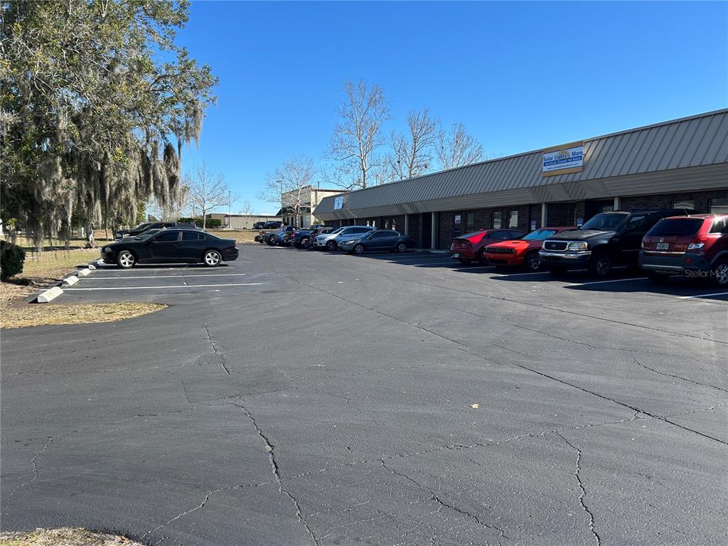 A parking lot sits in front of a single-story commercial building under a clear sky — 5640 SW 6TH PLACE UNIT 300, OCALA, FL