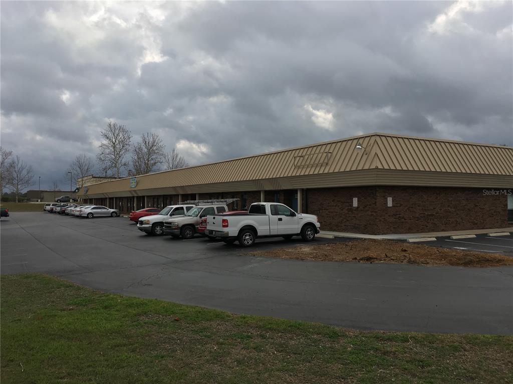 A single-story commercial strip mall with a brick facade and a tan metal roof — 5640 SW 6TH PLACE UNIT 300, OCALA, FL