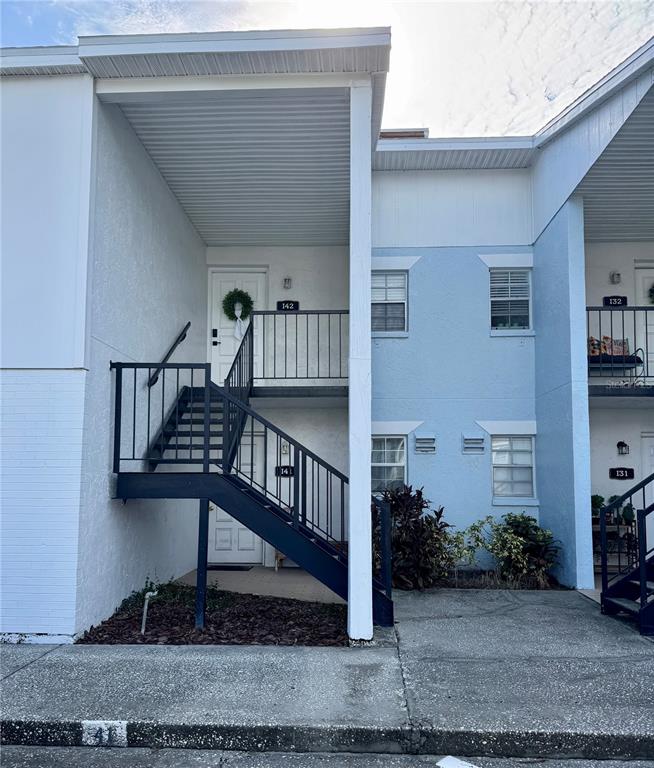 A white front door with a green wreath and a welcome mat at the entrance — 3819 N OAK DRIVE UNIT I42, TAMPA, FL