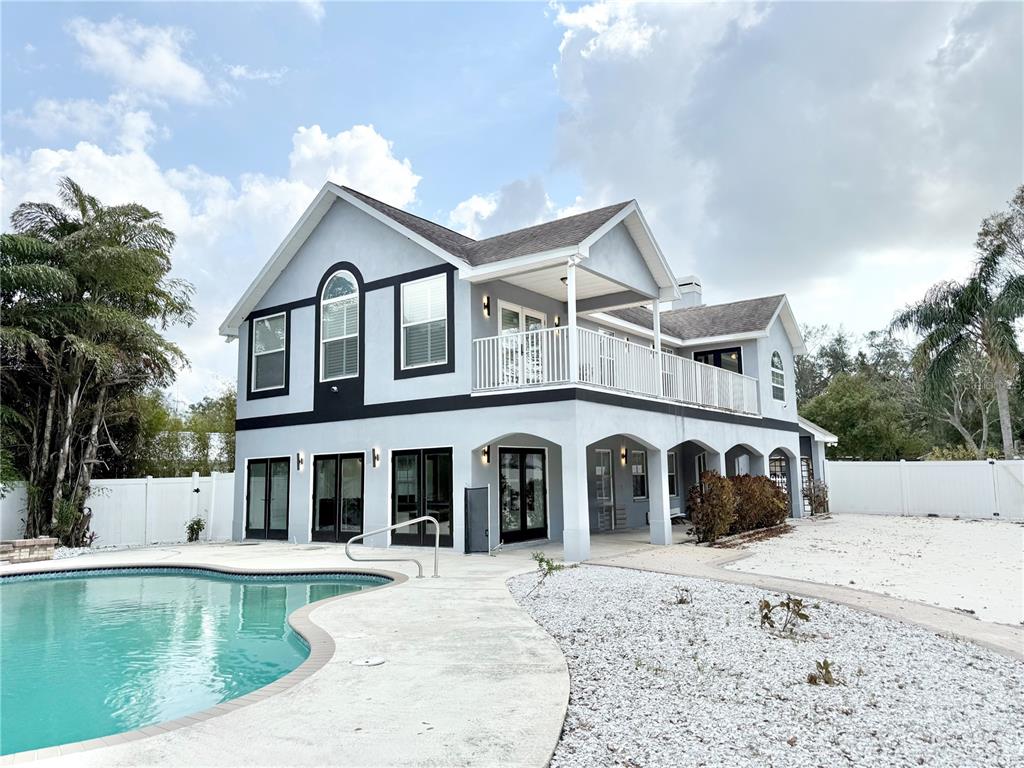 A two-story house with a swimming pool, white gravel landscaping, and a second-floor balcony — 6710 MYRNA DRIVE, TAMPA, FL