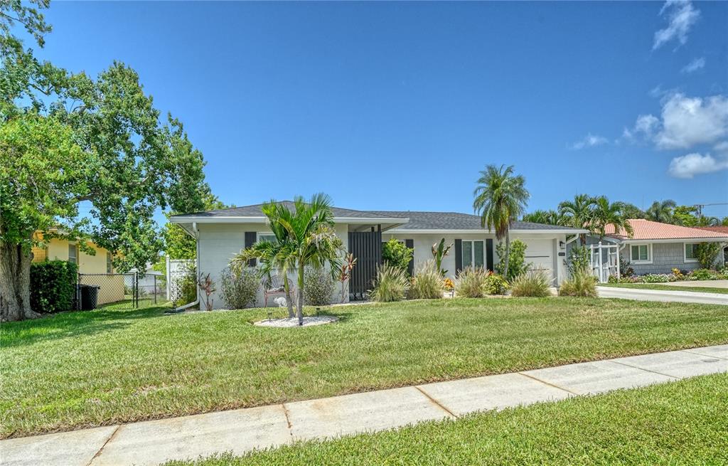 A single-story house with a white exterior, a dark roof, and palm trees in the yard — 6926 ANTIGUA PLACE, SARASOTA, FL