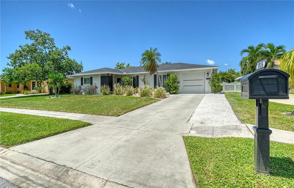 A single-story house with a concrete driveway, a white garage door, and a black mailbox — 6926 ANTIGUA PLACE, SARASOTA, FL
