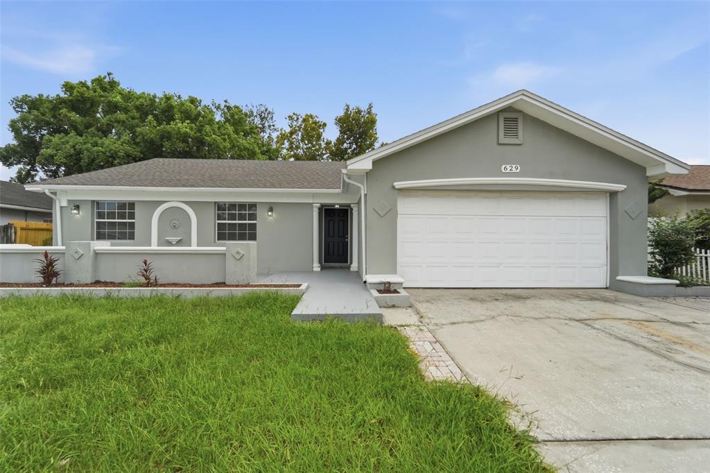 A single-story house with a gray exterior, a white garage door, and a front walkway — 629 LA SALLE DRIVE, ALTAMONTE SPRINGS, FL