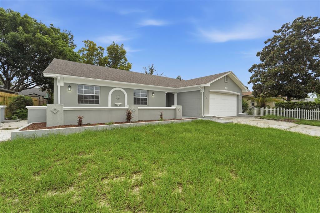 A single-story gray house with a white garage door, a front wall, and a grassy lawn — 629 LA SALLE DRIVE, ALTAMONTE SPRINGS, FL