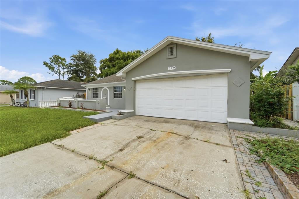 A single-story house with a gray exterior, a white garage door, and a concrete driveway — 629 LA SALLE DRIVE, ALTAMONTE SPRINGS, FL