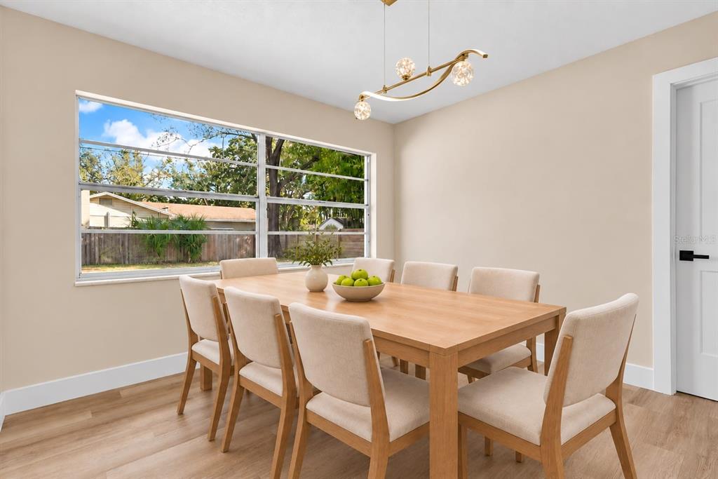 A bright room features light wood-look flooring, white walls, and dark exposed ceiling beams — 330 ELKHORN COURT, WINTER PARK, FL