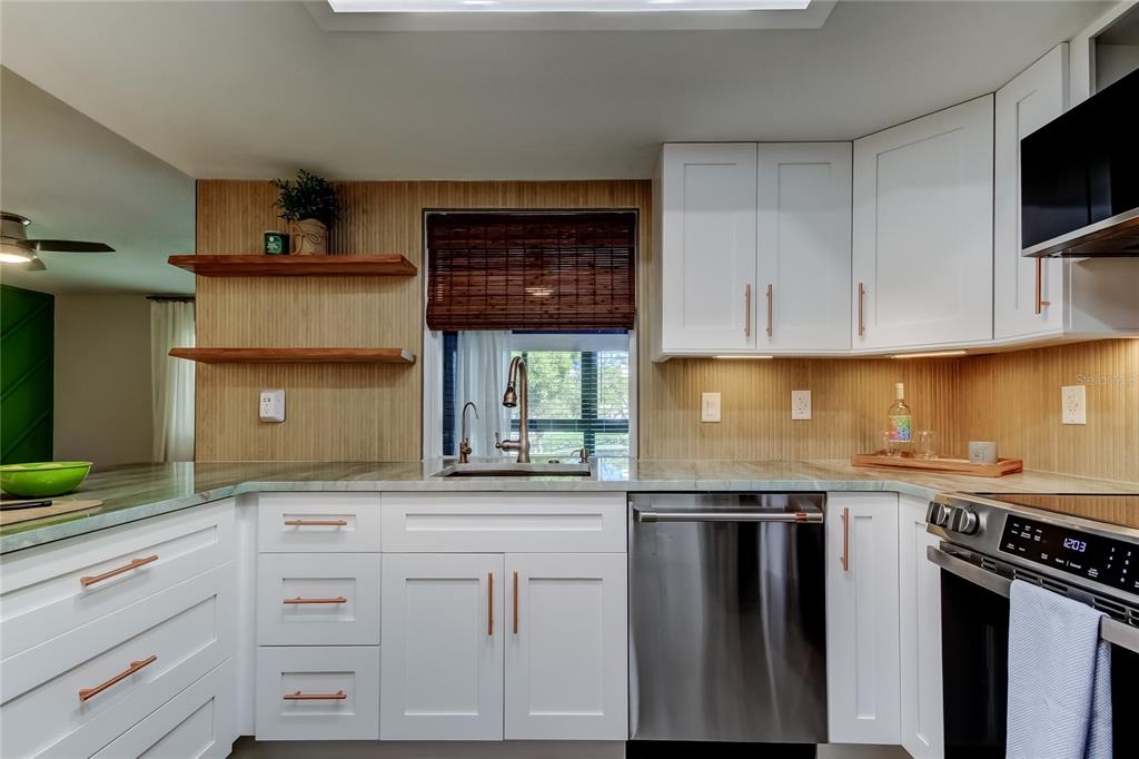 A breakfast nook features a corner built-in bench, a window, and a drum pendant light — 2673 SABAL SPRINGS CIRCLE UNIT 201, CLEARWATER, FL