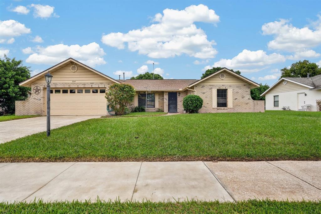 A single-story brick house with a two-car garage and a large front lawn — 104 COLLEEN DRIVE, DAYTONA BEACH, FL