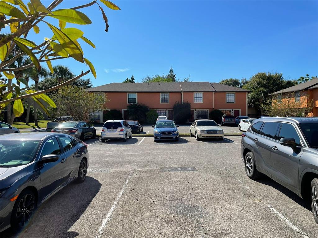A parking lot in front of a two-story apartment building under a clear blue sky — 7327 FOREST HILL COURT UNIT 223, WINTER PARK, FL