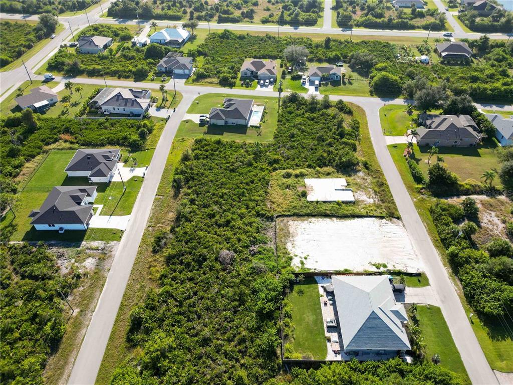 An aerial view shows several single-family homes and vacant lots in a suburban neighborhood — 13549 ABUTILON LANE, PORT CHARLOTTE, FL