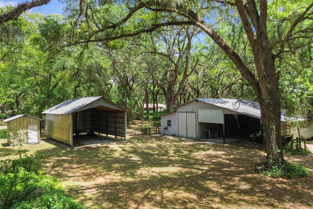 A bright red wooden porch swing hangs from a wooden frame in a grassy yard — 1153 CR 722, WEBSTER, FL