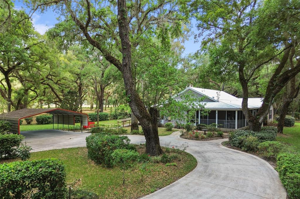 A gray house with a screened porch and a wooden wheelchair ramp in a yard — 1153 CR 722, WEBSTER, FL