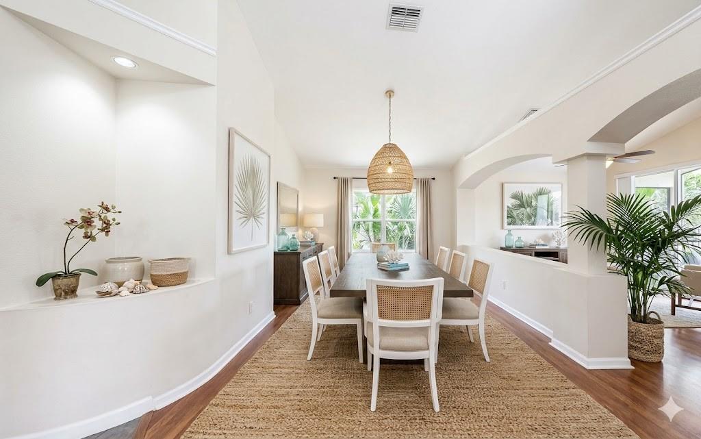 A dining room features a wooden table, cane-back chairs, a woven pendant light, and flooring — 7116 COLONY POINTE DRIVE, RIVERVIEW, FL