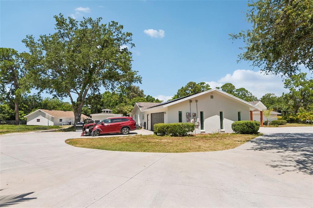 A red car is parked on a concrete driveway in front of a single-story house — 11295 131ST STREET, LARGO, FL