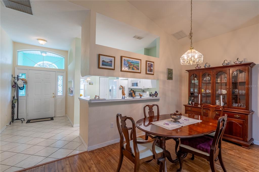 A dining room with a wooden table, hutch, and an open view into the kitchen — 10971 SW 69TH CIRCLE, OCALA, FL