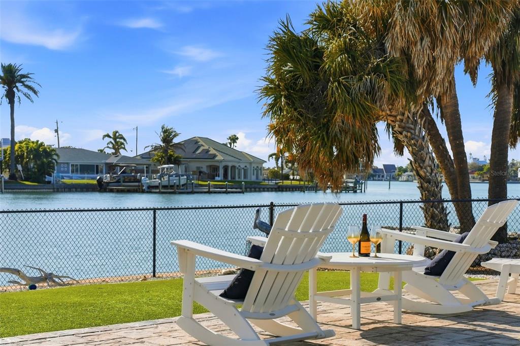 A wooden dock extends into the water with a boat lift and a small boat — 6420 3RD PALM POINT, ST PETE BEACH, FL