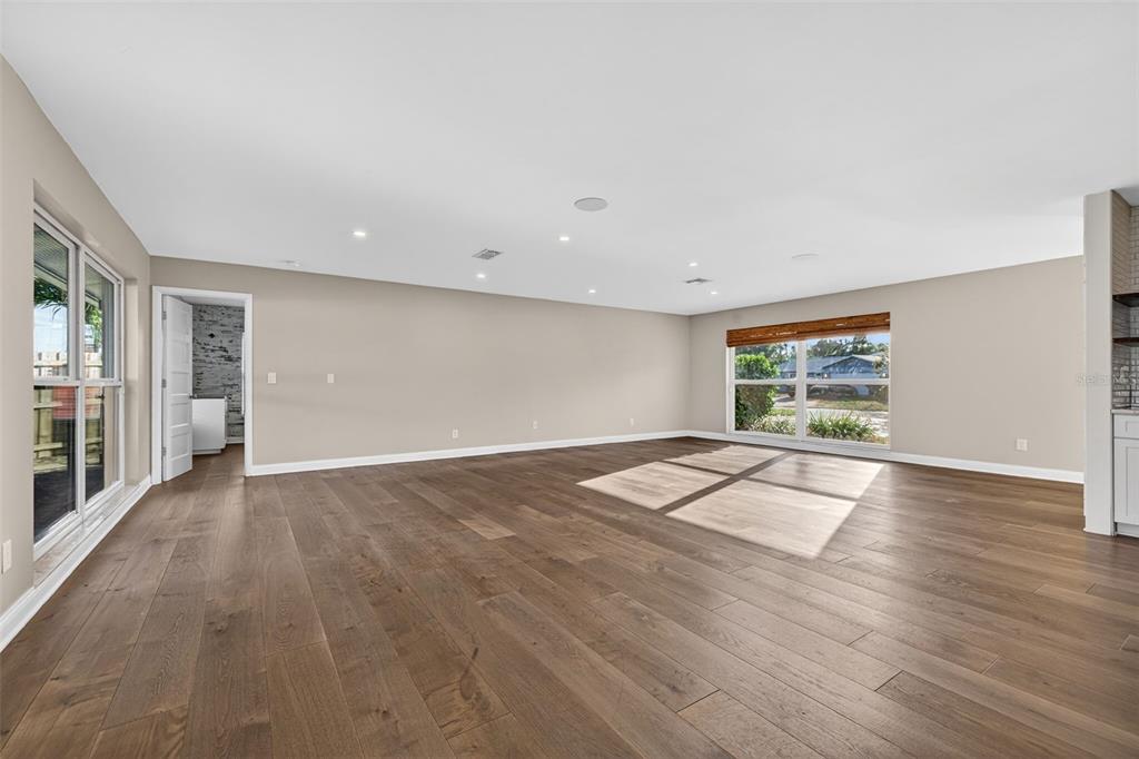 An open-concept living and dining area features light wood floors, recessed lighting, and neutral decor — 4200 BEACH DRIVE SE, ST PETERSBURG, FL