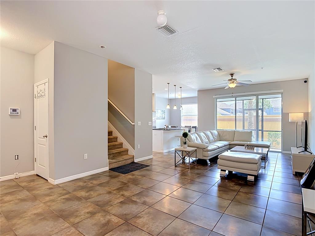 A two-story townhouse exterior features a brown garage door, a concrete driveway, and stone accents — 8615 ANDALUCIA FIELD DRIVE, TAMPA, FL