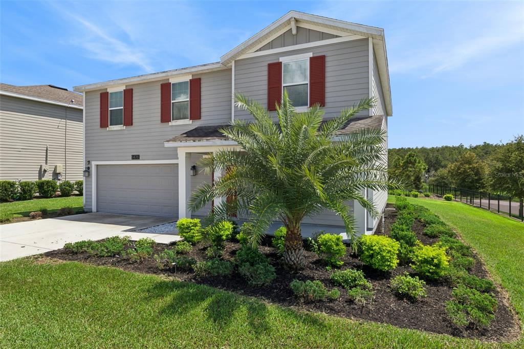 A two-story house with gray siding, red shutters, a garage, and a front yard palm tree — 5478 LIMESTONE STREET, MOUNT DORA, FL