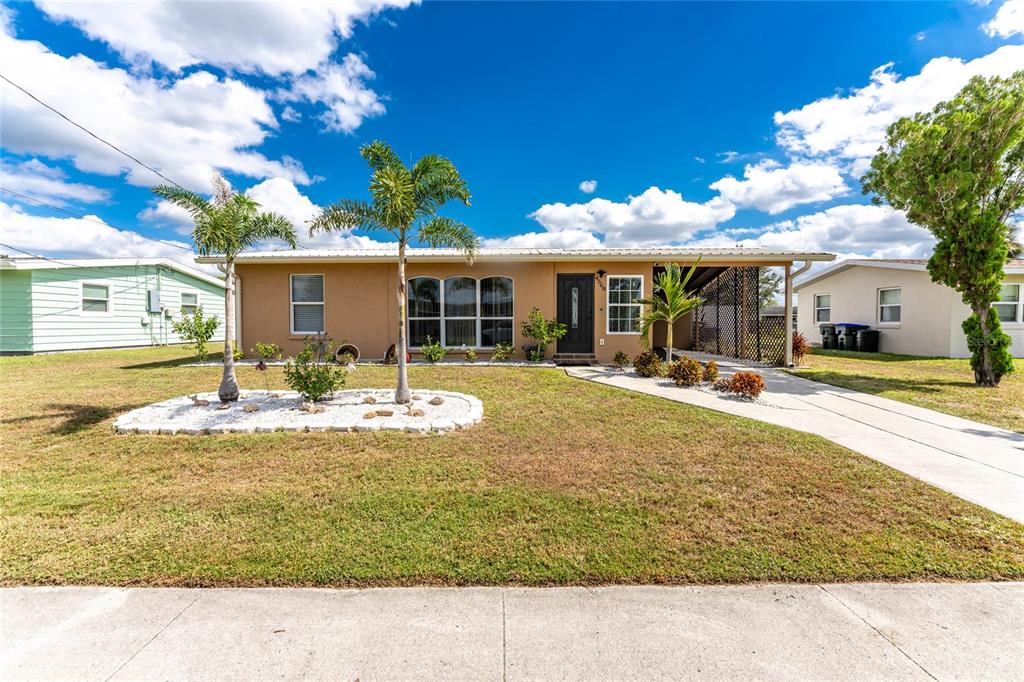 A single-story house with a tan exterior, a front lawn, and a paved driveway — 4568 GROBE STREET, NORTH PORT, FL