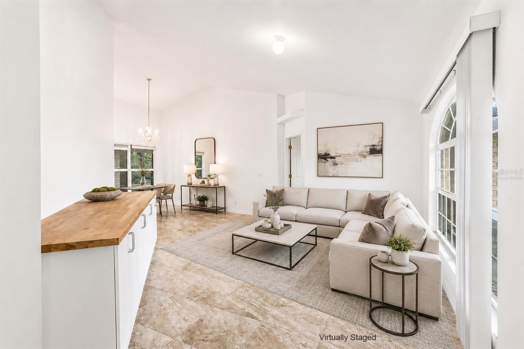 A living room with tile floors, a sectional sofa, and a kitchen island counter — 2007 N PARKTON DRIVE, DELTONA, FL