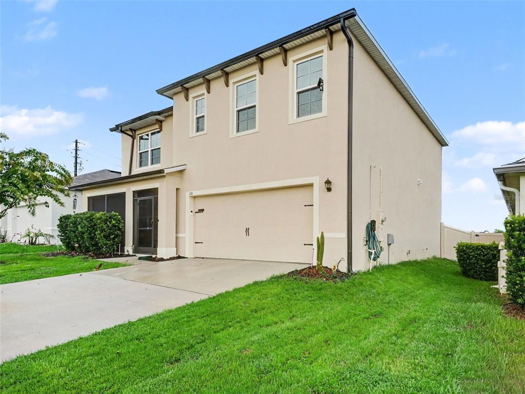 A two-story beige house with a two-car garage and a screened front entryway — 210 MEADOWBROOK BOULEVARD, WINTER HAVEN, FL