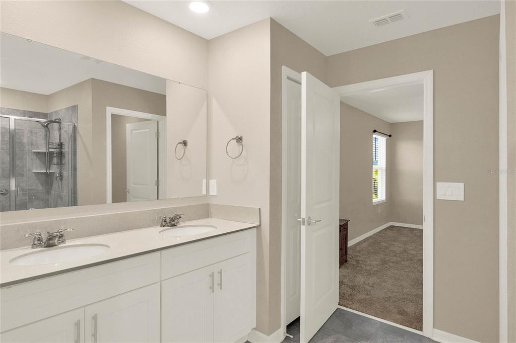 A bathroom features a double vanity with white cabinets and a large mirror — 271 INMAN BOULEVARD, WINTER HAVEN, FL