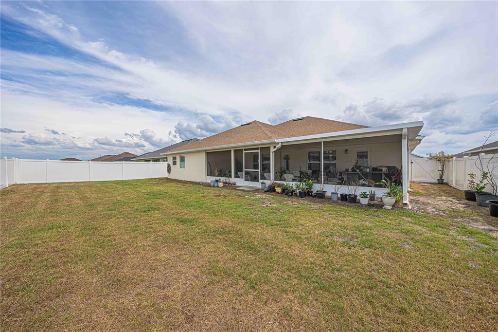 A single-story suburban house features a two-car garage, tan stucco siding, and a palm tree — 5035 SW 91ST PLACE, OCALA, FL