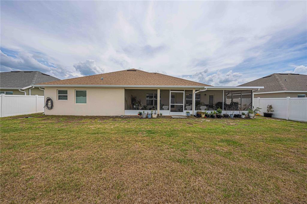 A single-story suburban house features a two-car garage, tan stucco siding, and stone accents — 5035 SW 91ST PLACE, OCALA, FL