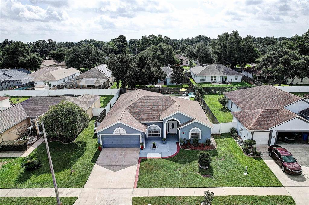 An aerial view of a single-story blue house with a two-car garage and lawn — 2242 TOWERING OAKS CIRCLE, SEFFNER, FL