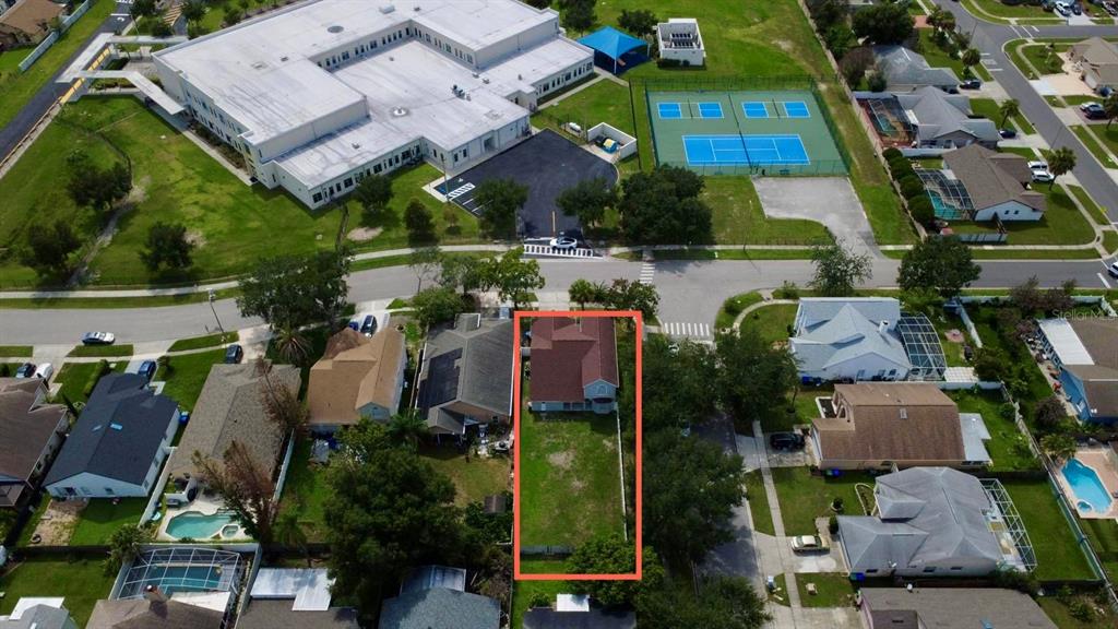 An aerial view shows a residential house with a large backyard highlighted by a red border — 12509 CRAYFORD AVENUE, ORLANDO, FL
