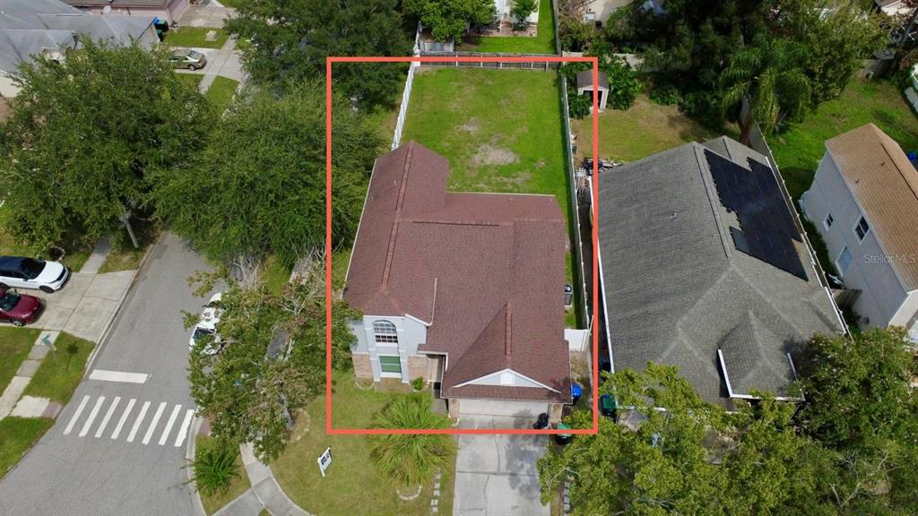 An aerial view shows a two-story house with a brown roof and a fenced backyard — 12509 CRAYFORD AVENUE, ORLANDO, FL