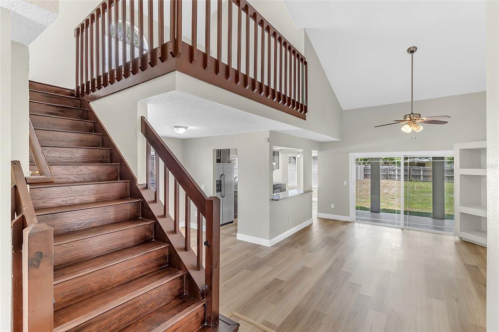 The exterior view shows the back of a two-story house with a large grassy yard — 12509 CRAYFORD AVENUE, ORLANDO, FL