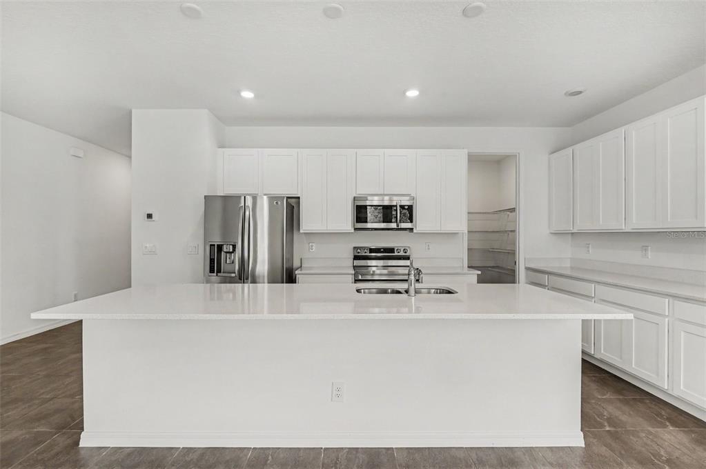 A single-story house with a beige stucco exterior, a two-car garage, and a concrete driveway — 1034 ALABASTER WAY, DELTONA, FL