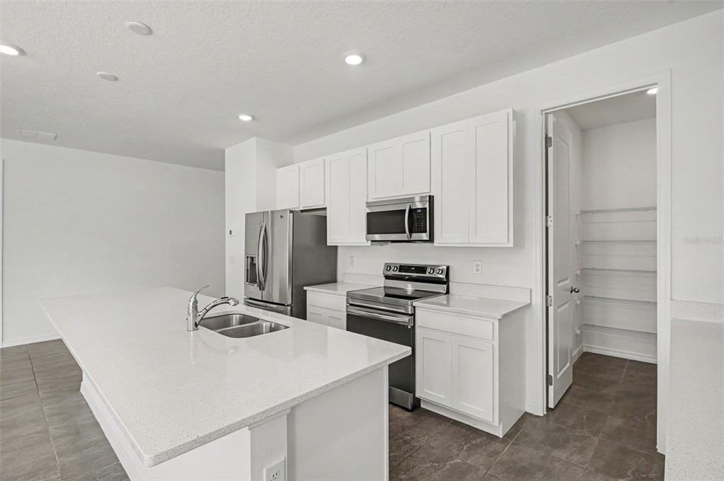 A single-story house with a light green exterior, a two-car garage, and a front lawn — 1034 ALABASTER WAY, DELTONA, FL