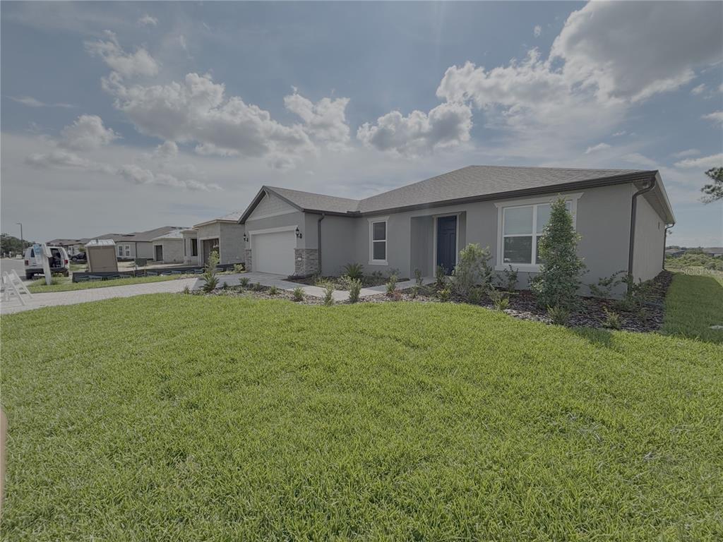 A single-story house with a gray stucco exterior, a two-car garage, and a front lawn — 6360 SW 82 TERRACE, OCALA, FL