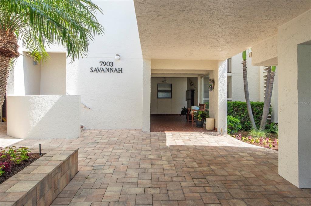 A hallway view showing two apartment doors numbered 102 and 103 with wall-mounted light fixtures — 7903 SAILBOAT KEY BOULEVARD S UNIT 102, SOUTH PASADENA, FL