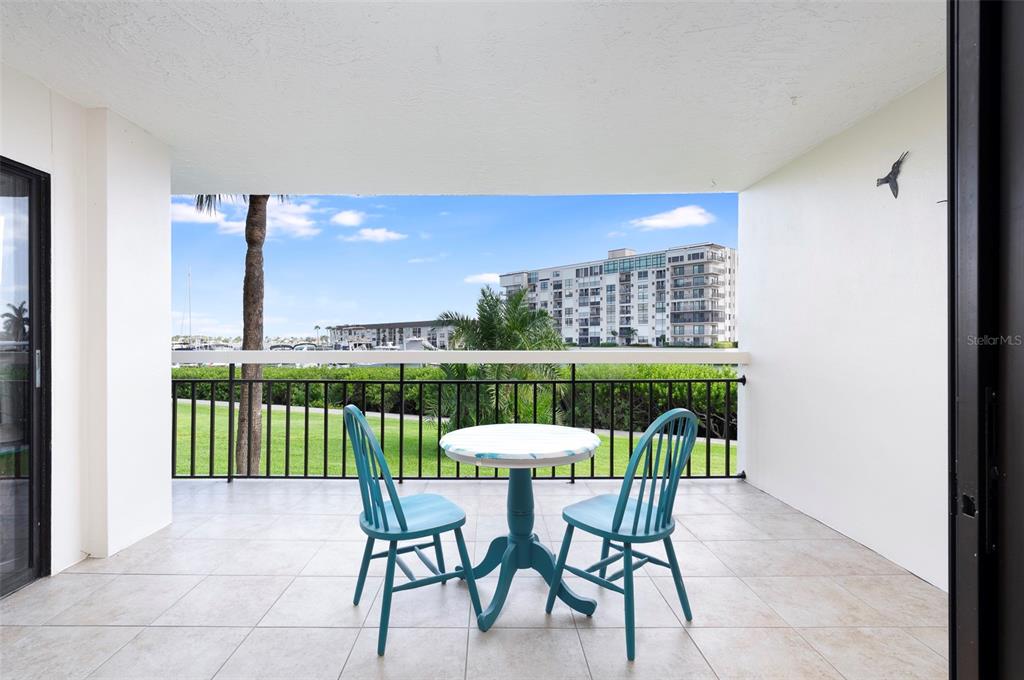 A hallway with a mirrored wall leads to a living area with a balcony view — 7903 SAILBOAT KEY BOULEVARD S UNIT 102, SOUTH PASADENA, FL