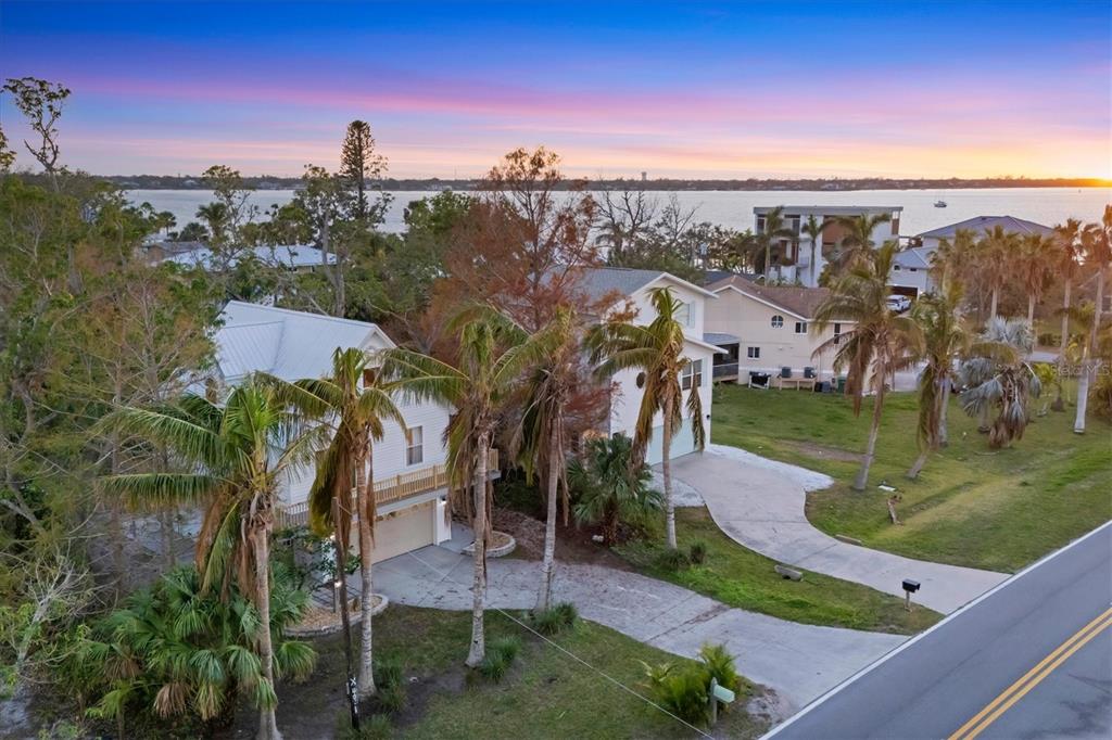 An aerial view of two houses with palm trees and a driveway near the water — 3403 10TH STREET W, PALMETTO, FL